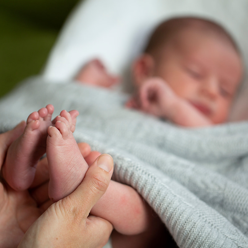 Photo of mother holding newborn babies feet.